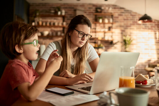 Young woman mother working from home with son