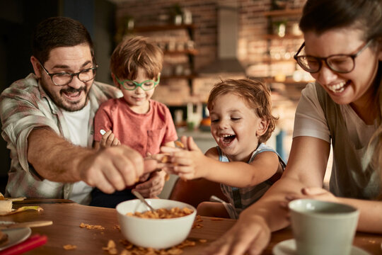 Happy young family eating meal at dining table