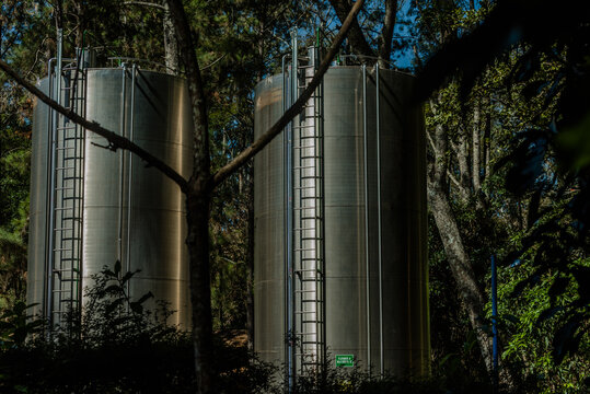 uma industria de envasamento de água mineral, com a imagem dos reservatórios em aço inox, no interior do Brasil, onde se tem as melhores fontes