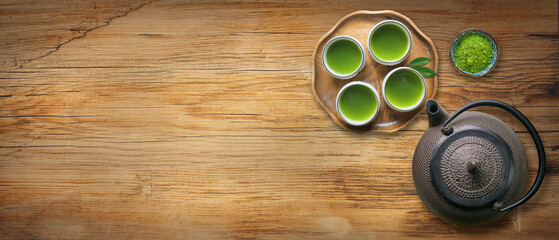 Cups of green tea with cast iron tea pot or kettle and fresh matcha powder                        