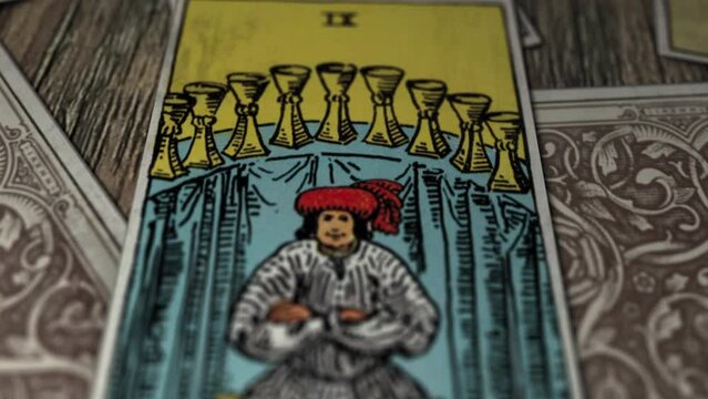 Paris, France - December 20, 2020: Man Sitting On Bench On Nine Of Cups Tarot Card. Card Means Satisfaction In Divination Ceremony. Esoteric Experience. Card For Future And Fortune Telling.