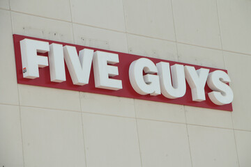 five guys logo writing caption text on storefront restaurant wall, close up