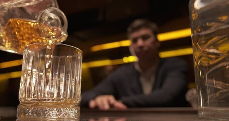Close-up pouring whiskey from the decanter. Glass of whiskey at the bar. Fine alcoholic drinks beverage. Selective focus