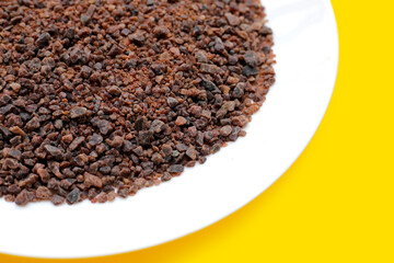 Black himalayan salt on yellow background.