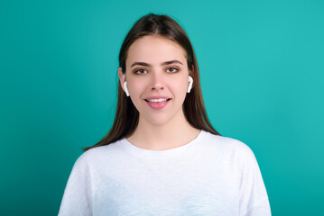Fototapeta premium Woman listening to music with earphones. Girl with headphones, wireless earphones. Listening music in earphone, studio. Earphones in ear. Woman using headphones. Ear buds, wireless earbud earphone.