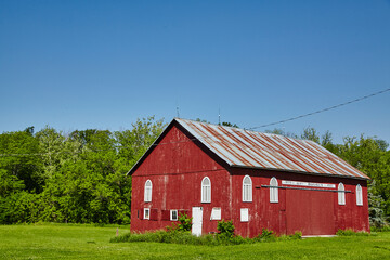 Obraz premium Rustic Red Barn Amidst Greenery in Fort Wayne, Indiana