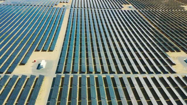 Drone of solar panels, agriculture and renewable energy or power plant for sustainability and eco friendly plate on field. Aerial view of photovoltaic grid on farming land and engineering background