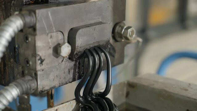 Close Up Of Melted Plastic Coming From Extruder Equipment. Plastic Compounding Plant. Melted Raw Material Falls Into Water For Cooling. Melted Plastic Extruding Process. Extruder Machine