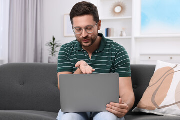 Man blowing kiss during video chat via laptop at home. Long-distance relationship