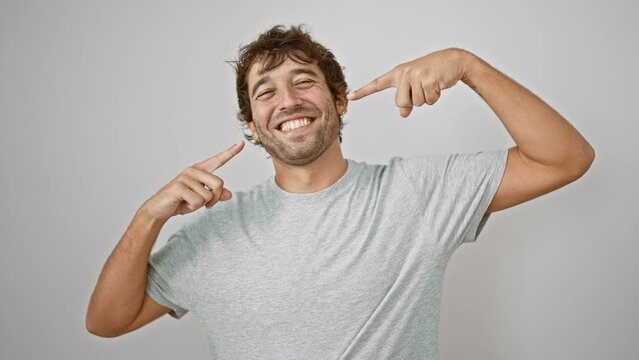 Joyful young man in casual t-shirt, pointing to his perfect teeth, showing off his dental health. laughing with his mouth wide, isolated on a white background. handsome guy with a fresh, clean smile!
