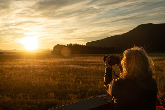 Taking pictures at Mendenhall Wetlands State Game Refuge at sunset; Juneau, Alaska