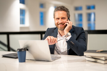 Naklejka premium Business man entrepreneur startup owner in modern office. Occupation person in work space. Business portrait. Confident business worker. Business man talking on phone at office workplace.