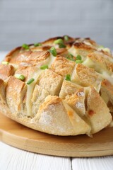 Freshly baked bread with tofu cheese and green onions on white wooden table, closeup