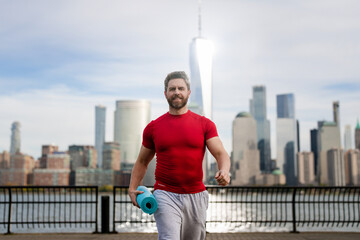 Athletic Mature Fit Strong Muscular Man with yoga mat in New York City. Athletic man workout in NYC. Athletic Senior. Sport, fitness and exercise. Athletic guy.