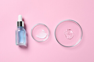 Bottle of cosmetic serum and petri dishes with samples on pink background, flat lay