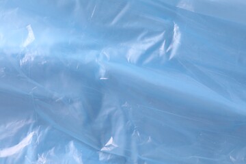 Texture of light blue plastic bag as background, closeup