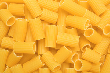 Raw rigatoni pasta as background, top view