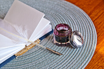 Vintage Writing Setup with Quill, Inkwell and Blank Paper on Wooden Desk