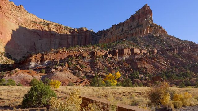 Establishing shot of mountains with red rocks background in Fruita Scenic Road, Capital Reef National Park, Utah, North America. Day time on October 2023. Still camera view. ProRes 422 HQ.