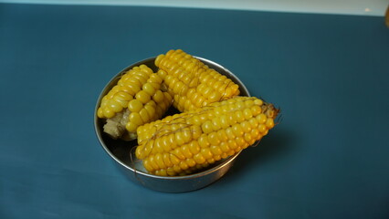 Boiled sweet corn on plain background taken from bird eye view.