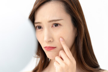 Fototapeta premium 鏡を見てお肌が気になる女性
