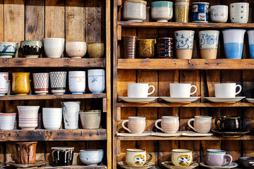 Various pottery ceramic displayed on wooden shelves at store. pottery ceramic on wooden shelves