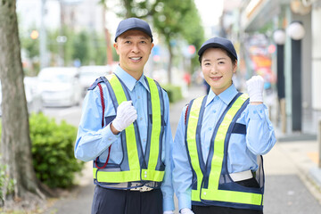 ガッツポーズをするアジア人の男女の警備員