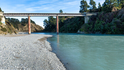 The bright blue transparent water in the Waimakariri river flowing through the rural Gorge in...