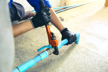 Obraz premium Technician plumber using a wrench to repair a water pump pipe. Concept of maintenance, fix water plumbing leaks drop or house bathroom service or cleaning clogged pipes is dirty or rusty.