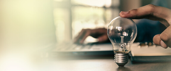 Hand choose light bulb for creative idea concept or innovation of technology in analyzing global...