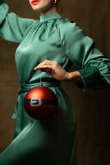A woman in a green dress holding a Christmas ornament