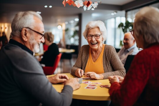 three elderly people with grey hair cheerfully playing card games with each other. Candid atmosphere of activities of mature friendship and growing old happily
