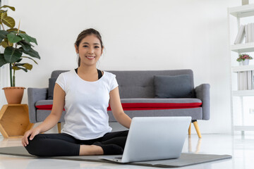 Online Yoga Tutorial: Young Woman Practices Yoga at Home