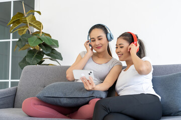  Two Women Relaxing and Listening to Music on a Couch