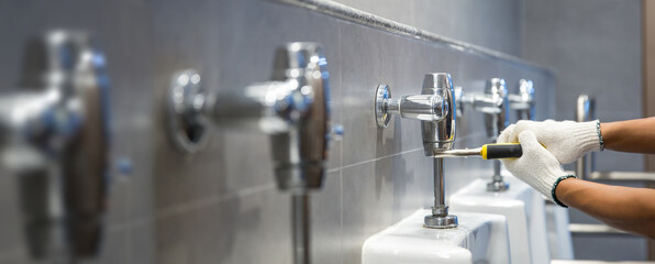 Hand of handyman or plumber is using a wrench to fix or repair leaking water pipes, faucets or...