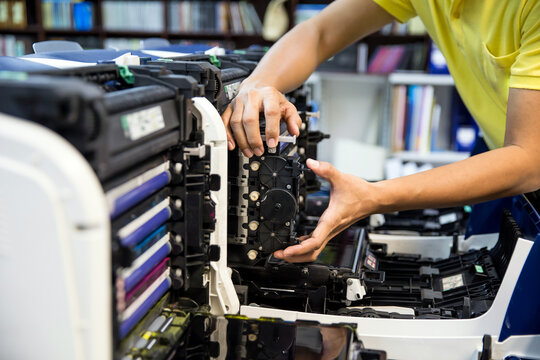 Technician hand open cover photocopier or photocopy to fix repair copier problem paper jam and replace ink cartridges for scanning fax or copy document in office workplace concept of service support.