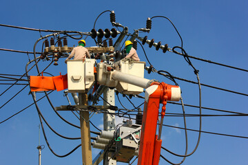 electric engineering team working on cradle of aerial platform or crane connected high voltage...