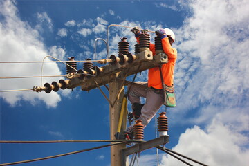 electric worker repair high voltage transmission lines on pole against blue sky - obrazy, fototapety, plakaty