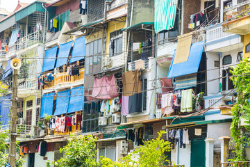 Close up of high rise apartment windows with awnings and laundry hanging to dry at Hanoi in Vietnam