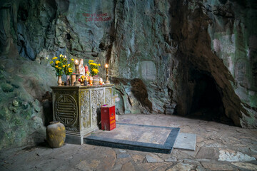 A small alter and shrine inside a dimly lit cave temple at Marble Mountain at Da Nang in Vietnam