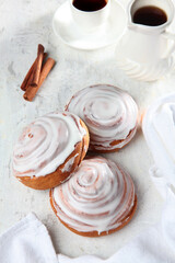 A bun with icing sugar on a light background. The concept of breakfast.