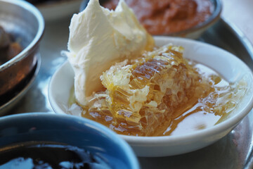 butter cream and honey in a bowl on table .