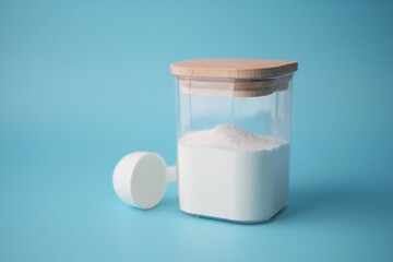 baby milk powder in container with a spoon on blue background.