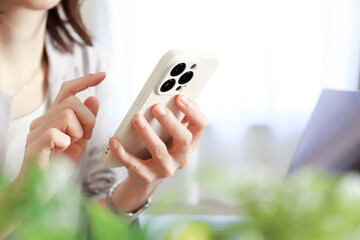 スマホを使う女性の手元　ビジネスイメージ