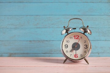 Vintage clock on pastel pink and blue wooden background