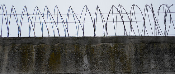 prison. the walls of a prison with barbed wire.