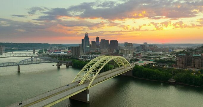 Daniel Carter Beard in Cincinnati city, Ohio, USA with highway traffic driving cars in downtown district. American city skyline with brightly illuminated high commercial buildings at sunset