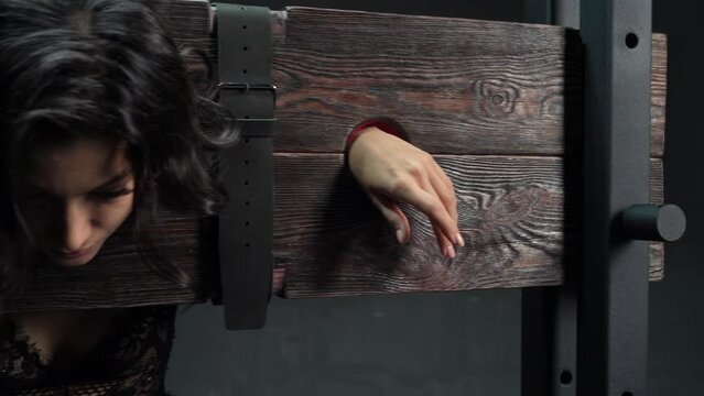 Sexy woman locked on BDSM bench during sexual game