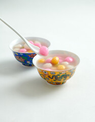 Tang yuan, tangyuan, delicious red, yellow and white rice dumpling balls isolated on white background. Asian traditional festive food for Chinese Winter Solstice Festival, selective focus.