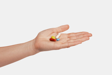 Colorful pills and tablets in the woman hand